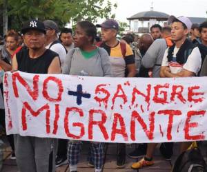 Migrantes sostiene un cartel durante una caravana rumbo a Estados Unidos, este martes, en el municipio de Tapachula en el estado de Chiapas (México) coincidendo con el proceso electoral que se desarrolla en EUA.