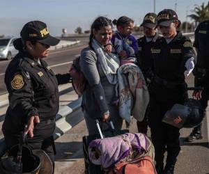 Policías hablan con migrantes en el paso fronterizo de control entre Santa Rosa (Perú) y Chacalluta (Chile).