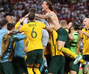 Los jugadores de Australia celebran ganar el partido de play-offs entre confederaciones de la Copa Mundial de la FIFA 2022 entre Australia y Perú el 13 de junio de 2022, en el estadio Ahmed bin Ali en la ciudad qatarí de Ar-Rayyan. Australia venció a Perú en una tanda de penales a muerte súbita para asegurar el penúltimo lugar libre en la final de la Copa del Mundo.