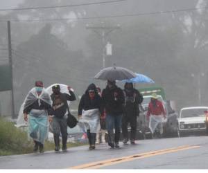 Fotografía de archivo en donde un grupo de personas camina por una vía tras las fuertes lluvias en Chiriquí (panamá).