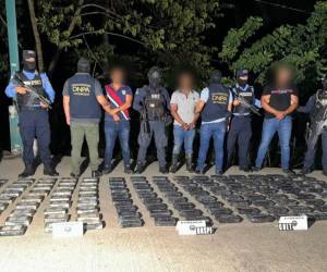 Los tres detenidos por la Policía Nacional (PN), junto a la evidencia de los 136 kilos de cocaína.