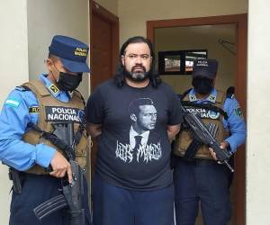 El abogado y presunto miembro de la MS-13, es custodiado por dos elementos de la Dirección Policial Anti Maras y Pandillas Contra el Crimen Organizado (Dipampco).