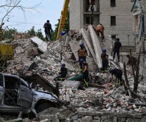 Los rescatistas despejan la escena después de que un edificio fuera parcialmente destruido como resultado del impacto de un misil ruso en un edificio residencial de cuatro pisos en Chasiv Yar, distrito de Bakhmut, este de Ucrania, el 10 de julio de 2022. Al menos seis personas murieron y otras cinco fueron resultó herido en un ataque ruso a un edificio de apartamentos en la ciudad de Chasiv Yar, dijo un funcionario local.