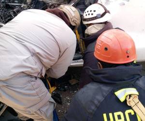 Dos personas fallecieron tras quedar atrapadas dentro de la cabina aplastada y cuatro resultaron heridas tras el impacto entre un pick-up y una rastra cargada de arena en el kilómetro 15 de la carretera al sur. Aquí los detalles del difícil rescate de los cuerpos.