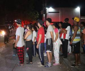 Migrantes se preparan para recibir comida este martes en campamentos improvisados en el municipio de Tapachula en Chiapas.