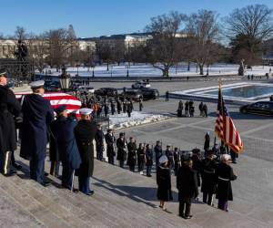 Cubierto con la bandera, el ataúd del expresidente estadounidense Jimmy Carter es transportado por un equipo conjunto de portadores de féretros fuera del Capitolio Estados Unidos en Washington.