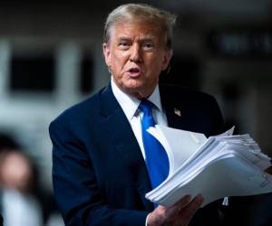 Fotografía de archivo tomada el 18 de abril de 2024 al expresidente de los Estados Unidos, Donald Trump, con documentos a su salida de una audiencia en una corte de Manhattan en Nueva York, Estados Unidos.