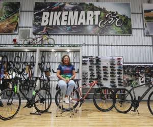 Gennie Flores posando en Bike Mart con los modelos de bicicletas que se sortearán en la Vuelta.