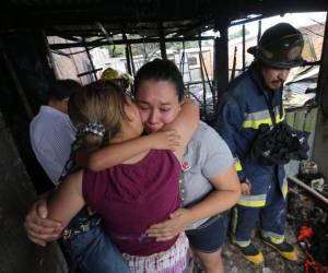 Una vecina abraza a una de las damnificadas mientras esta llora al saber que estuvo a punto de morir carbonizada con sus hijos.