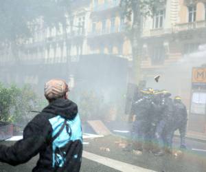 Un manifestante enfrenta a los oficiales de policía durante una manifestación para conmemorar el día internacional de los trabajadores.