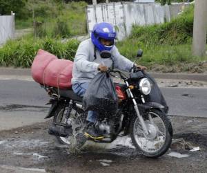 Este conductor de motocicleta estuvo a punto de caer al pasar por un gigantesco bache en el anillo periférico.