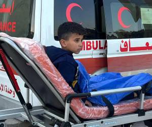 Un niño palestino herido es llevado a una ambulancia en el cruce fronterizo de Rafah en Egipto después de ser evacuado de la Franja de Gaza, el 25 de diciembre de 2023