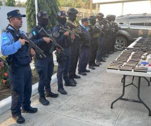 La Policía Nacional posa con el arsenal de armas que decomisaron en San Pedro Sula.