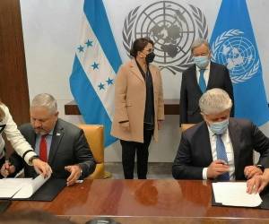 Momento en que el Canciller de la República revisa la documentación previo a la firma que da vida a la CICIH. Al fondo la presidenta de Honduras y el titular de la ONU.