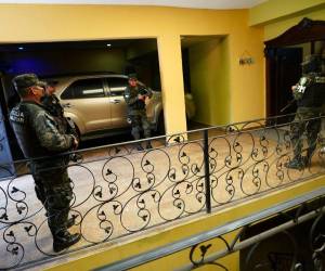 Miembros de la Policía Militar de Honduras hacen guardia en una lujosa casa durante una redada en Tegucigalpa el 12 de diciembre de 2022.