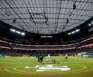 Los trabajadores pintan el campo del Allegiant Stadium en Las Vegas, Nevada, el 10 de febrero de 2024, en preparación para el Super Bowl LVIII.