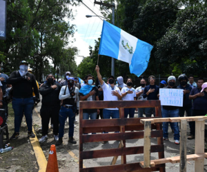 Guatemaltecos elevan pancartas frente a la Fiscalía y otras instituciones estatales.