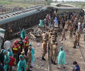 Guardabosques paramilitares y voluntarios inspeccionan los vagones en el lugar del accidente luego del descarrilamiento de un tren de pasajeros en Nawabshah el 6 de agosto de 2023.