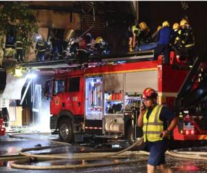 Bomberos intentan sofocar el fuego en el establecimiento.