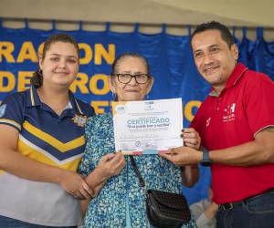 <i>Ciudadana recibe su certificado de alfabetización después de completar el programa.</i>