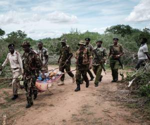 El personal de seguridad lleva a un joven rescatado del bosque en Shakahola, en las afueras de la ciudad costera de Malindi.