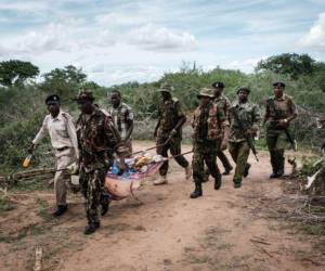 Personal de seguridad lleva a un joven rescatado del bosque en Shakahola, en las afueras de la ciudad costera de Malindi.