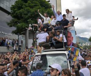 La líder opositora venezolana María Corina Machado y el candidato presidencial Edmundo González Urrutia saludan a sus partidarios durante una manifestación.