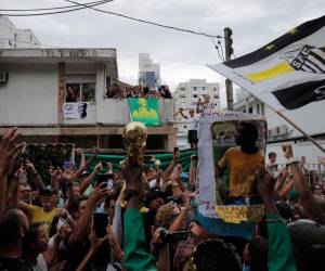 Los fanáticos de la difunta estrella del fútbol brasileño Pelé se reúnen en la calle mientras un camión de bomberos transporta el ataúd de Pelé al Cementerio Conmemorativo de Santos en Santos, estado de Sao Paulo, Brasil el 3 de enero de 2023. La procesión fúnebre a través de Santos pasará por la casa de Pelé madre, Celeste Arantes, de 100 años, que aún vive. Terminará en el Cementerio Conmemorativo de Santos, donde se llevará a cabo un funeral católico antes de que Pele sea enterrado en un mausoleo especial.