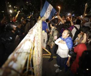 Un fuerte contingente policial de antimotines detrás de vallas metálicas impide esta noche el paso a los hondureños que se han sumado a la marcha de las antorchas que busca llegara a Casa Presidencial para exigir a la mandataria que rectifique su decisión de denunciar al tratado de extradición o su renuncia.