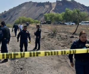 Agentes de policía hacen guardia en un área donde se encontró una supuesta fosa común clandestina y un crematorio en el sureste de la Ciudad de México el 1 de mayo de 2024.