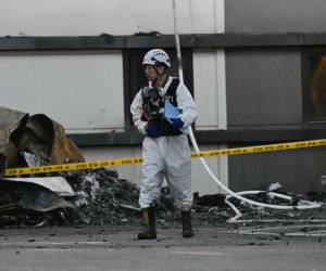 Un investigador de los servicios de bomberos camina en el lugar tras un incendio en una fábrica de baterías de litio propiedad del fabricante surcoreano de baterías Aricell en Hwaseong el 24 de junio de 2024.