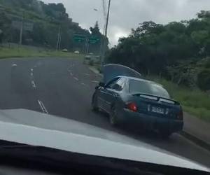 Hombre viaja en el tonó de un carro sin preocuparse por provocar un accidente.