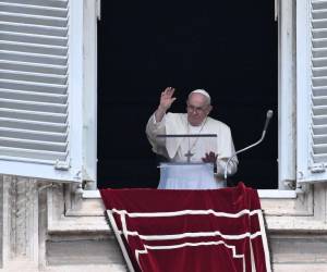 El Papa Francisco saluda a la multitud desde la ventana del palacio apostólico con vista a la plaza de San Pedro durante la oración semanal del Ángelus el 27 de agosto de 2023 en el Vaticano.