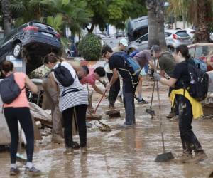 Vecinos y personas de diversas comunidades autónomas trabajan como voluntarios para restablecer la normalidad en Alfafar (Valencia) tres días después de las inundaciones que han asolado la provincia.