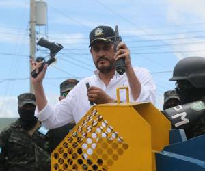 El ministro José Manuel Zelaya Rosales muestra los pedazos de un AR-15 después de ser destruido con una guillotina.