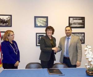 Roberto Martínez, cónsul de Honduras en New Orleans en el momento de la firma con la representante de la cooperativa.