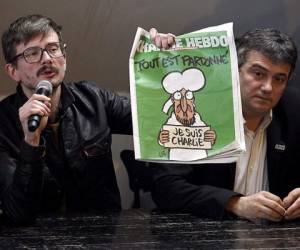 El caricaturista Renald Luzier sostiene un ejemplar del semanario francés satírico Charlie Hebdo.