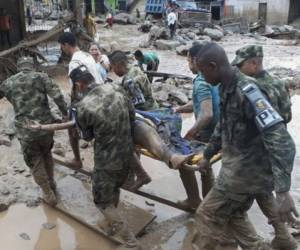 Soldados cargan los cadáveres de las víctimas de avalancha en Colombia. Fotos: AFP