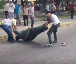 Dos jóvenes suspenden la estatua para terminar de destrozarla ante los gritos de celebración de los presentes (Foto: Redes Sociales/ El Heraldo Honduras/ Noticias de Honduras)