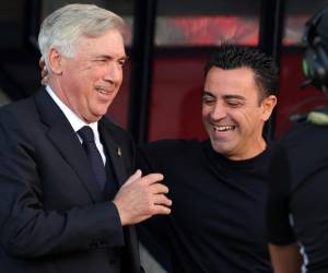 El entrenador italiano del Real Madrid, Carlo Ancelotti, y el técnico español del Barcelona, Xavi, se saludan antes del partido del clásico entre Barcelona y el Real Madrid, previo a que los equipos luchen en la grama.