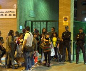 familiares y amigos de la enfermera española esperan noticias en las afueras del hospital de Madrid, resguardado por policías.