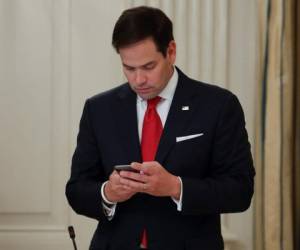 Marco Rubio, R-Fla. Revise su teléfono antes de tomar su asiento para un almuerzo organizado por el presidente Donald Trump.