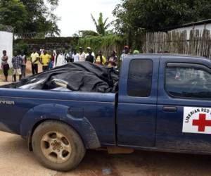 Un auto de la Cruz Roja liberiana traslada los cuerpos sin vida de personas fallecidas por el ébola.