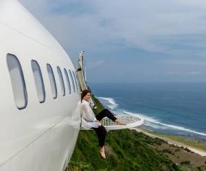 El avión de pasajeros está situado al borde de un acantilado, asomando inquietantemente una de sus alas sobre el abismo a 150 metros sobre el nivel del océano. Un huésped observando del paisaje marino desde el avión.