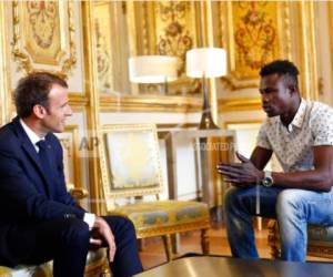 El presidente francés Emmanuel Macron, a la izquierda, conversa con Mamoudou Gassama, de 22 años, de Malí, en el Palacio del Elíseo, en París, el lunes 28 de mayo de 2018.