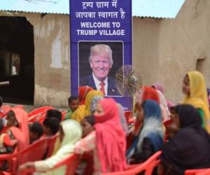 Indian women gather to listen to a speaker next to a poster with the image of US President Donald Trump during a ceremony at Marora village, which has been unofficially renamed 'Trump Village,' about 100km from New Delhi, on June 23, 2017.A rural Indian settlement with little electricity or running water renamed itself 'Trump Village' on June 23 in an unusual gesture to the American president ahead of Prime Minister Narendra Modi's trip to Washington. A huge billboard declaring 'Welcome to Trump Village' in Hindi and English, accompanied with a beaming portrait of the US president, was unveiled in Haryana state's Marora, as the village is officially known. The water and sanitation group Sulabh, which has been installing toilets in the impoverished settlement, suggested the name change to the local council. / AFP PHOTO / MONEY SHARMA