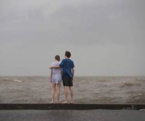 MANDEVILLE, LUISIANA - La gente ve cómo se rompen las olas contra un muro de inundación en un parque a lo largo de la orilla del lago Pontchartrain después de que el área se inundó tras el huracán Barry el 13 de julio de 2019 en Mandeville, Louisiana.