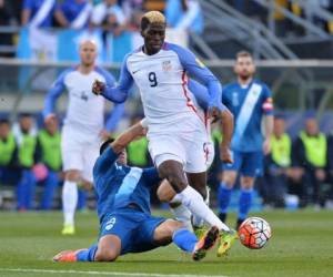 Rafael Morales # 14 de Guatemala se desliza para lanzar el balón lejos de Gyasi Zardes # ​​9 de los Estados Unidos.