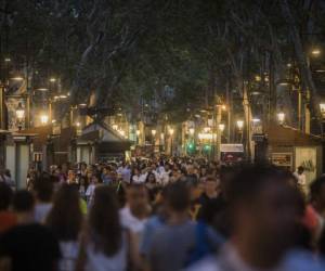 Un día después de un atentado terrorista, la gente camina por la calle histórica de Las Ramblas, en Barcelona, España, el viernes 18 de agosto de 2017. La policía disparó el viernes a cinco personas que llevaban cinturones de bombas conectados al ataque de la furgoneta de Barcelona. La caza del hombre se intensificó para los perpetradores del último alboroto de Europa reclamado por el grupo del Estado islámico. (Foto AP / Santi Palacios)