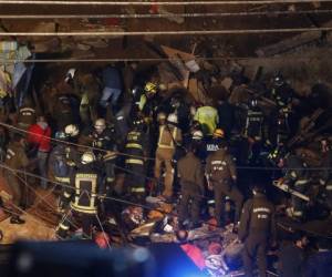 Imagen publicada por Aton Chile que muestra a los bomberos que trabajan en el sitio donde se derrumbó una casa luego de un derrumbe en una colina en Valparaíso, Chile, el 13 de agosto de 2019. - Al menos cuatro personas murieron debido al deslizamiento de tierra (Foto de Raul ZAMORA / ATON CHILE / AFP).